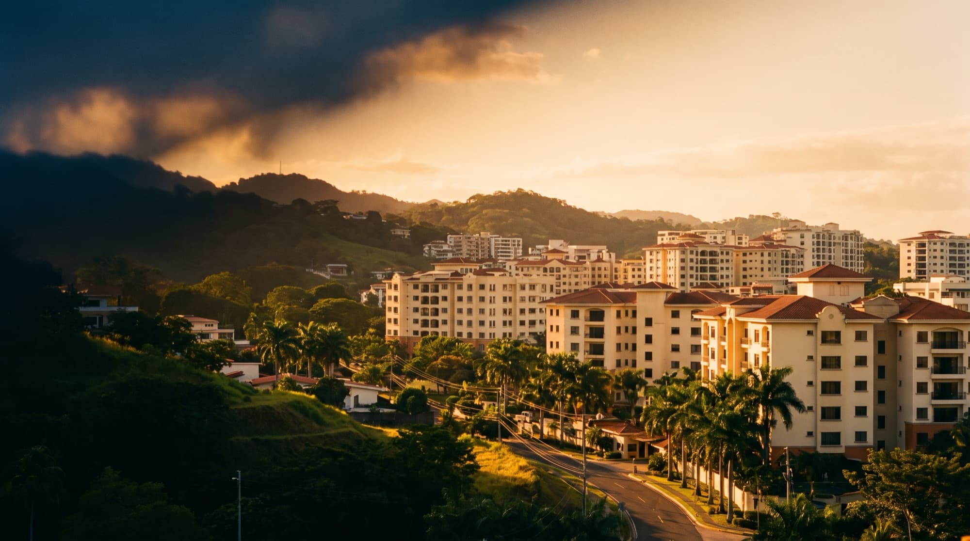 Golden-hour view of a modern Central American city set among green hills