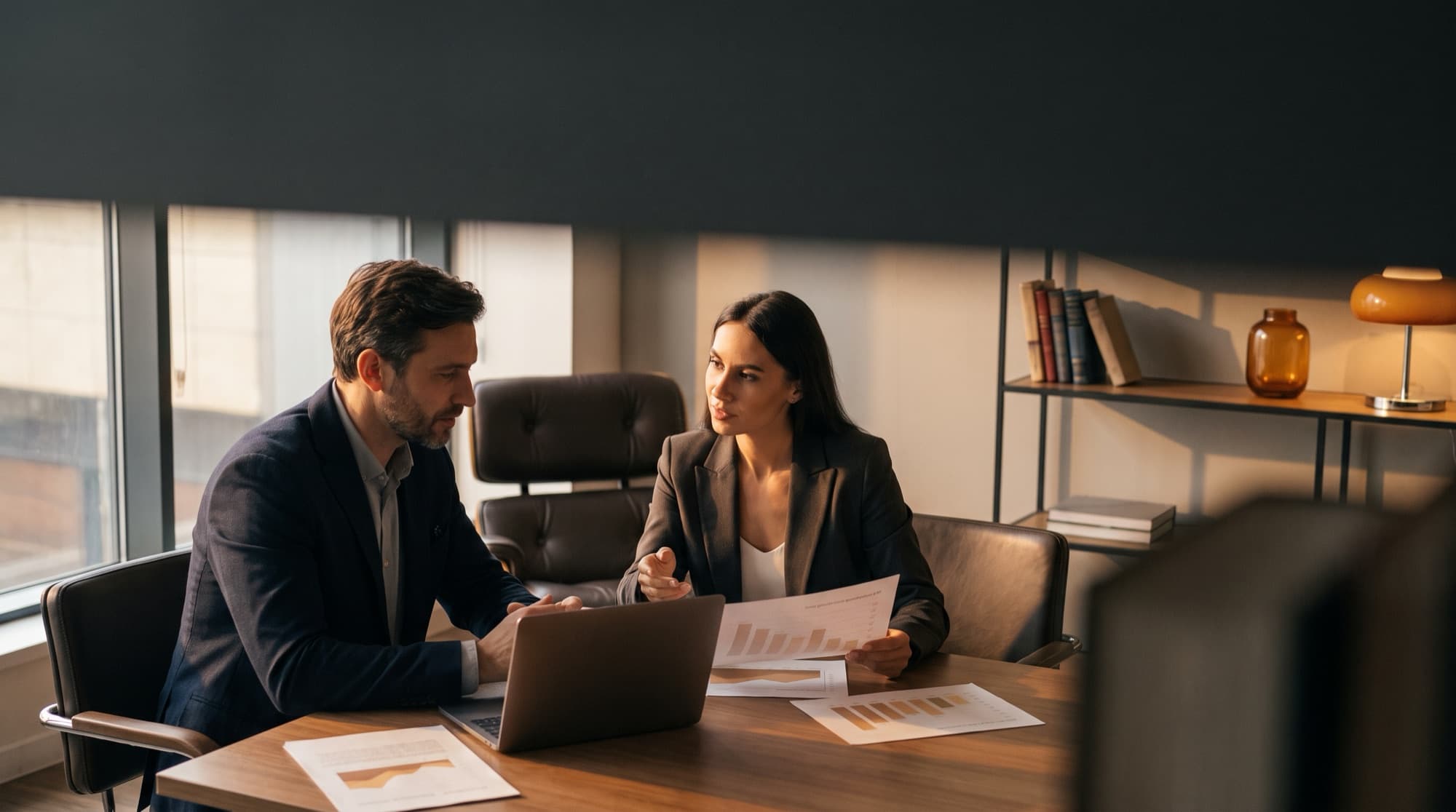 Two professionals comparing outsourcing providers over documents in a modern office