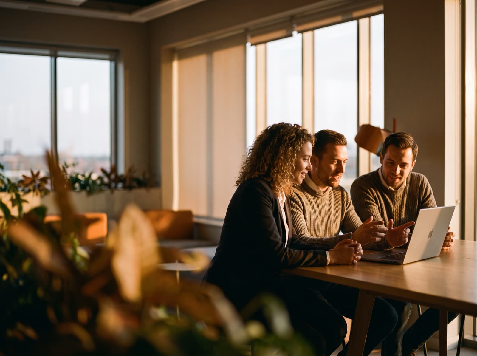 A SaaS support and product team collaborating around a laptop in a modern office