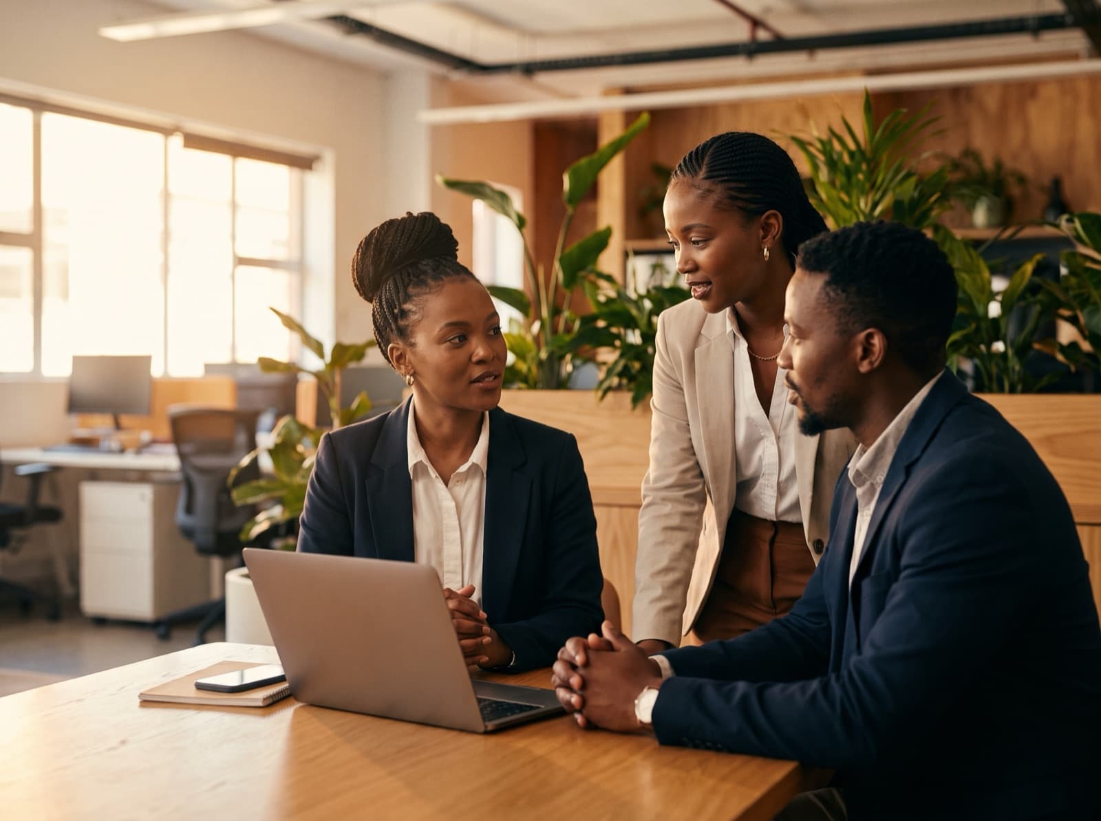 A team of South African customer-experience professionals collaborating around a laptop in a modern office